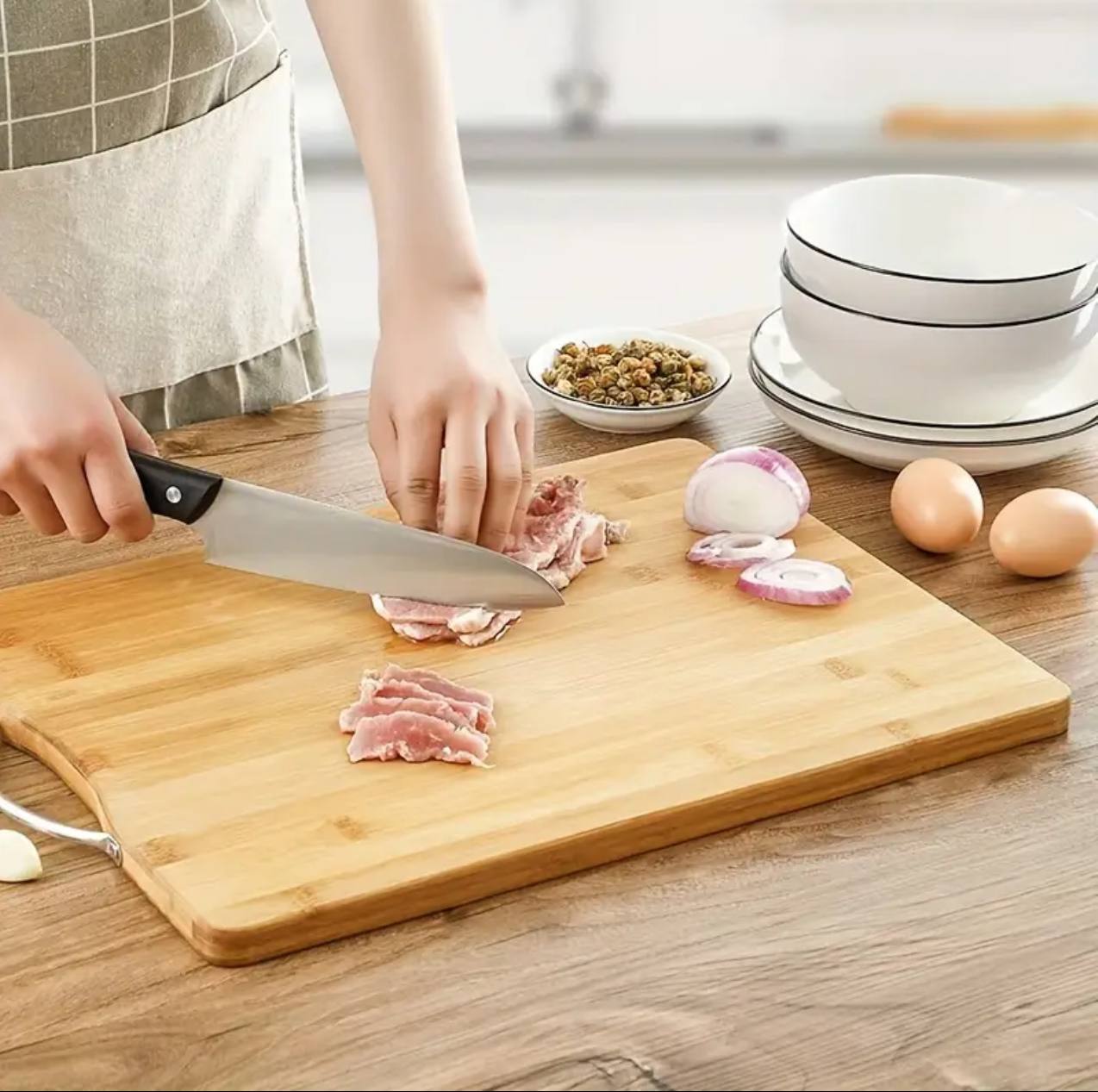 Heavy wooden chopping board with metallic handle.