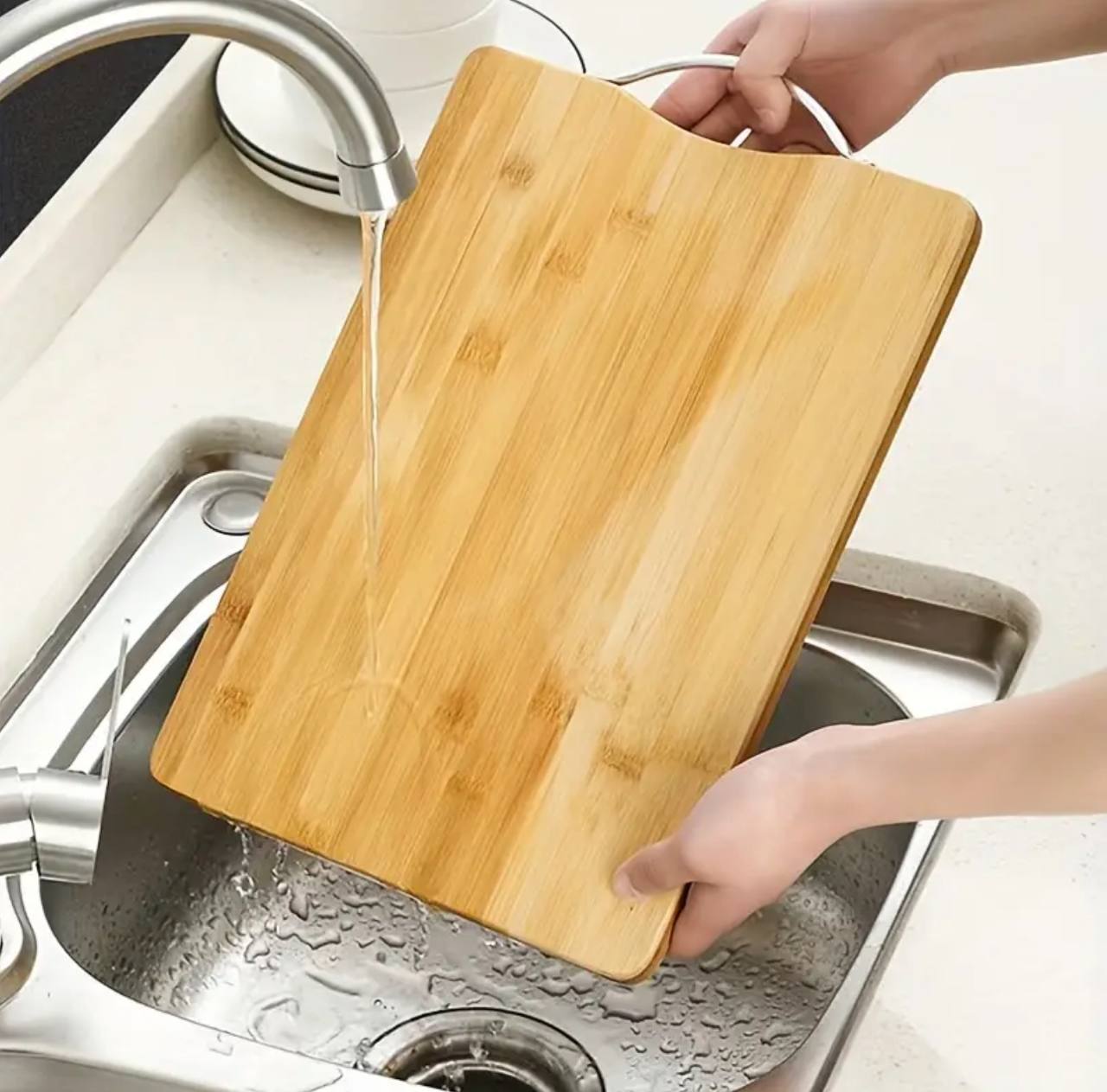 Heavy wooden chopping board with metallic handle.