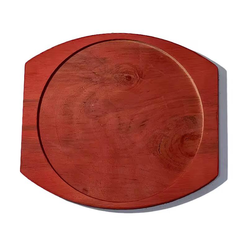 Cast iron hot sizzling plate on wooden tray